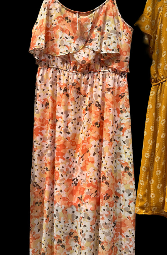 Floral dress with orange and white pattern hanging on a rack.