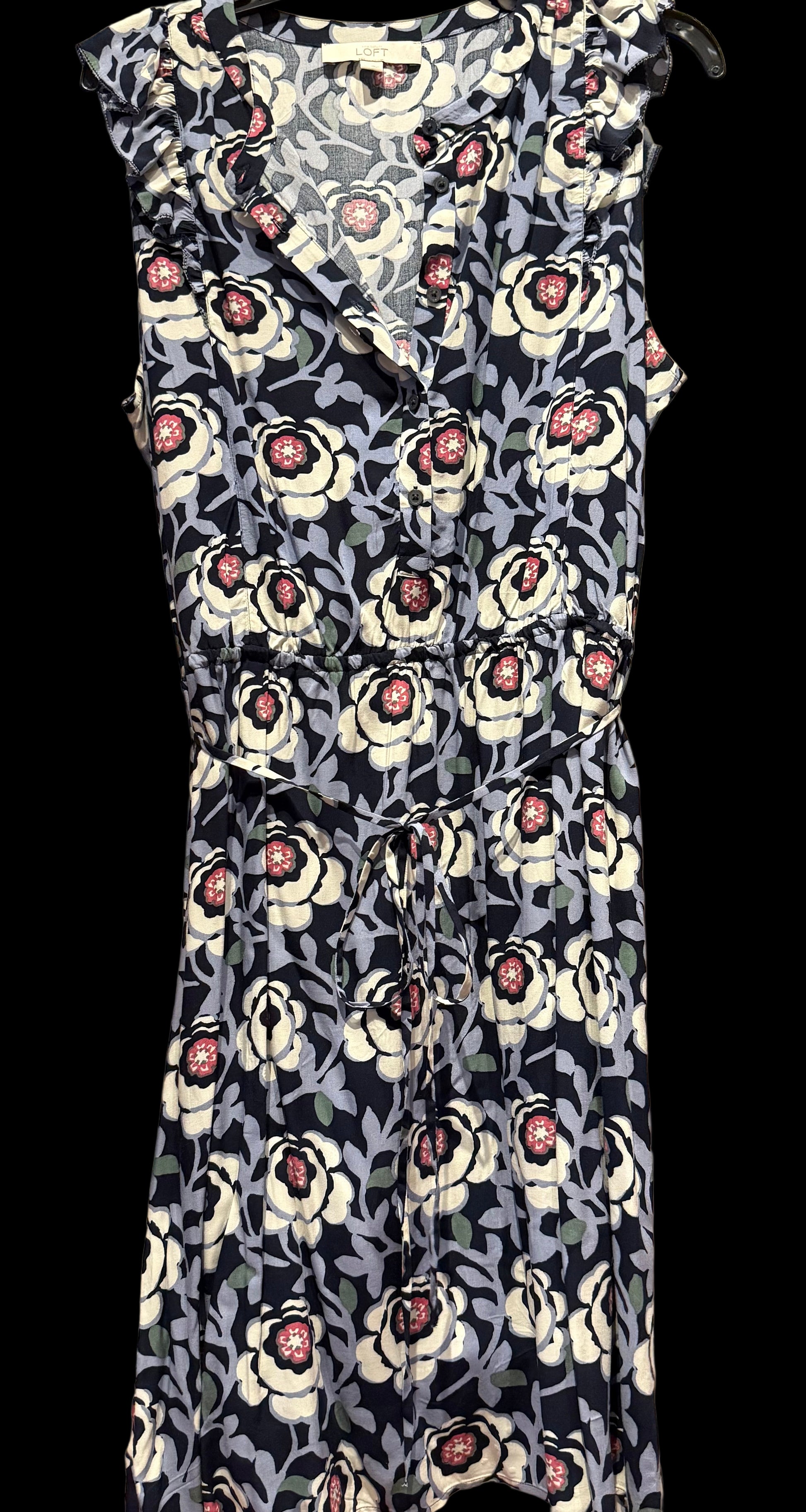 Floral dress with black, white, and pink pattern on a wooden rack.
